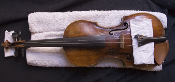A rolled towel stabilises the postion of the violin.